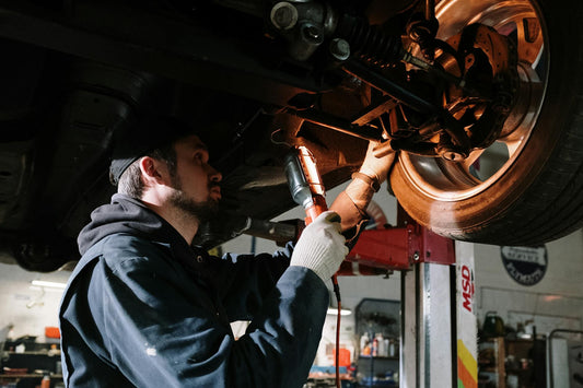Automotive technician inspecting vehicle identification plate during compliance check