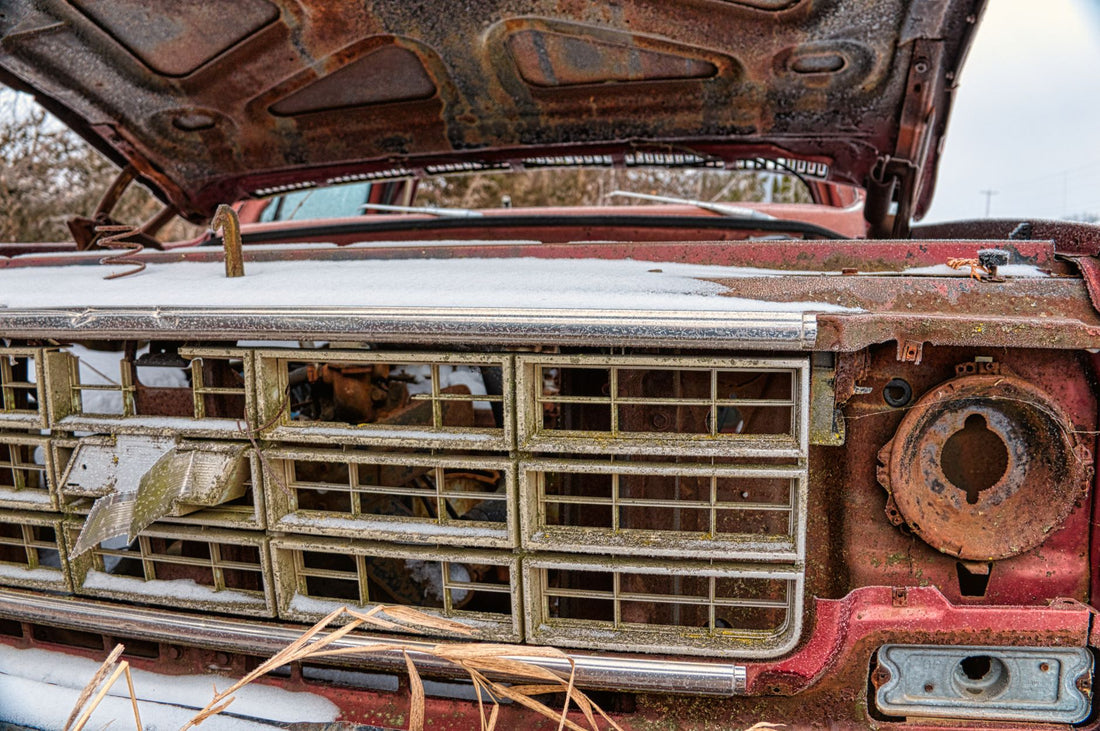 Corroded VIN plate on a classic car showing white oxidation and illegible stamped numbers requiring replacement