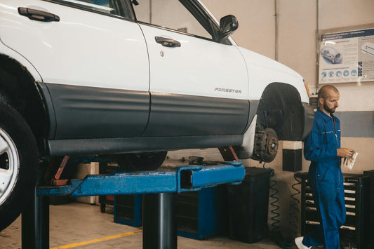 Mechanic inspecting vehicle identification plate for authenticity