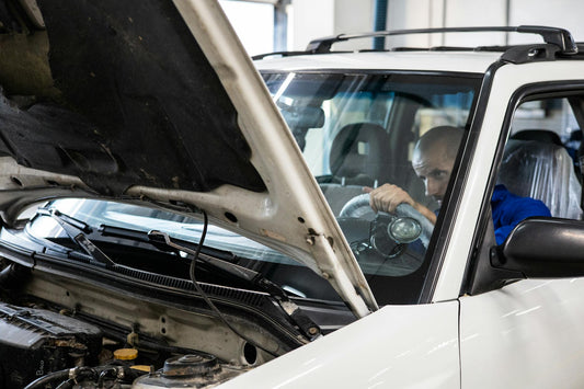 Expert automobile inspectant la plaque VIN d'un véhicule lors d'une expertise